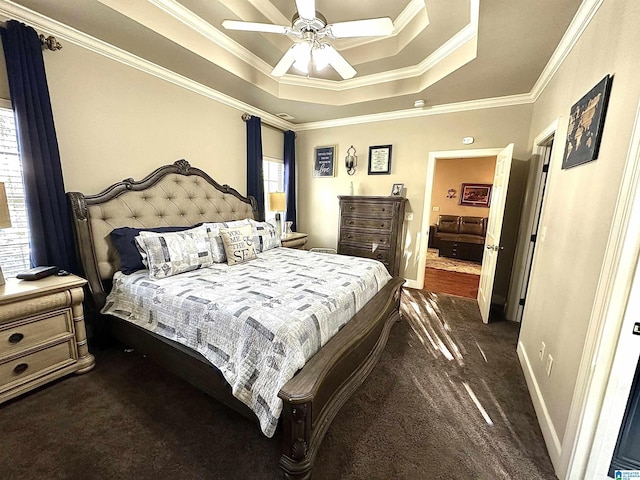 bedroom featuring ceiling fan, baseboards, ornamental molding, dark carpet, and a raised ceiling