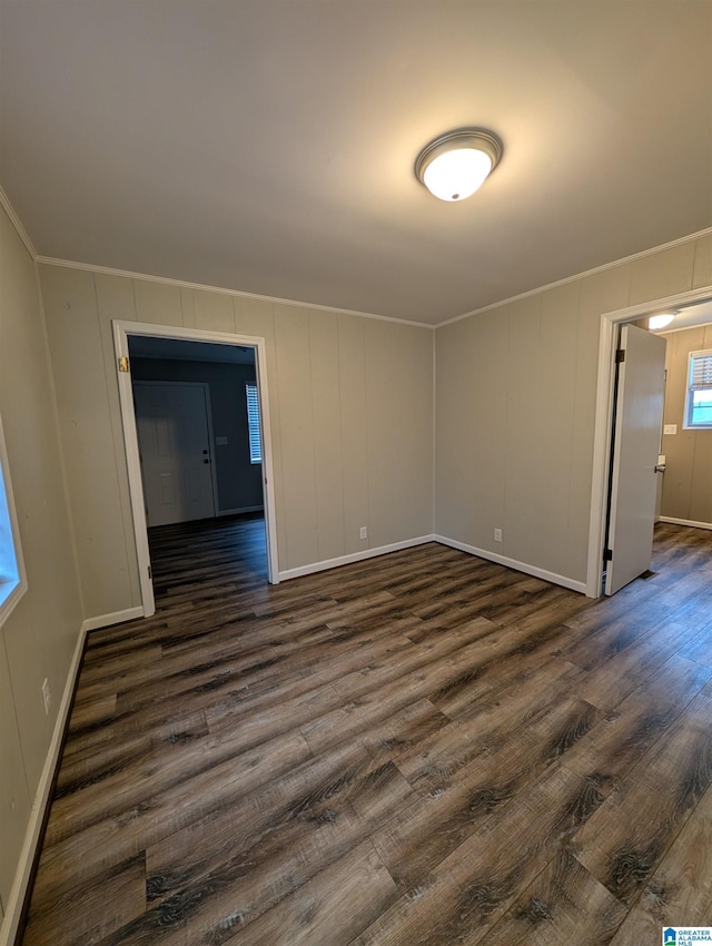 empty room featuring dark hardwood / wood-style flooring and ornamental molding