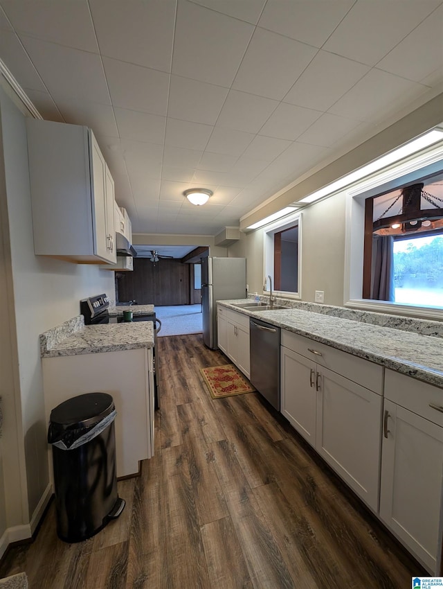 kitchen with white cabinetry, stainless steel appliances, light stone counters, and sink