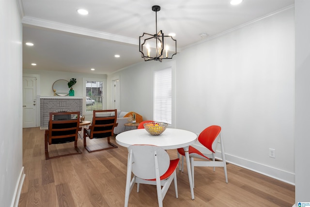 dining area featuring recessed lighting, baseboards, ornamental molding, a brick fireplace, and light wood finished floors