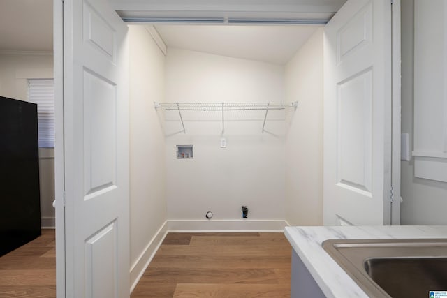 laundry room with hookup for a washing machine, laundry area, baseboards, and wood finished floors