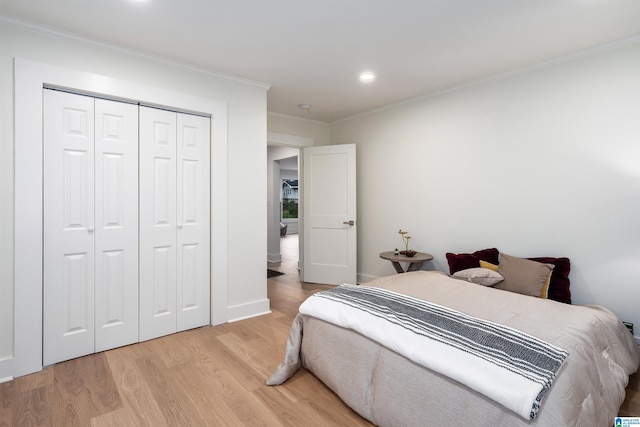 bedroom with recessed lighting, a closet, ornamental molding, light wood-type flooring, and baseboards