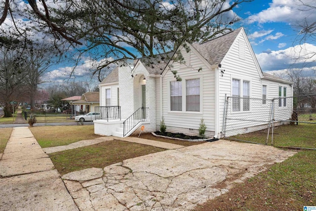 view of front of house with crawl space, a shingled roof, fence, and a front yard