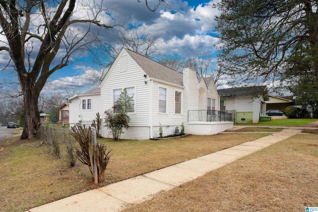 view of front of house featuring roof with shingles, a front lawn, crawl space, and a chimney