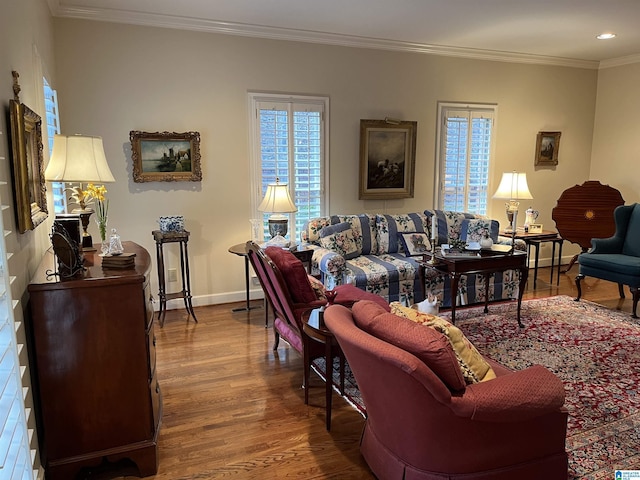 living area with ornamental molding, recessed lighting, wood finished floors, and baseboards