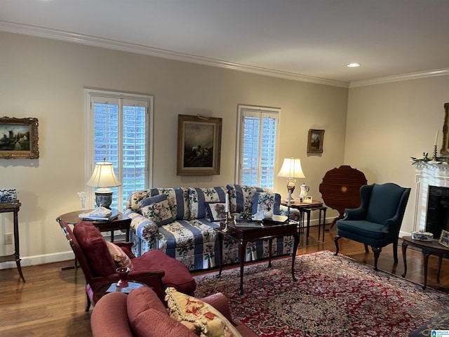 living area with plenty of natural light, a fireplace, crown molding, and wood finished floors