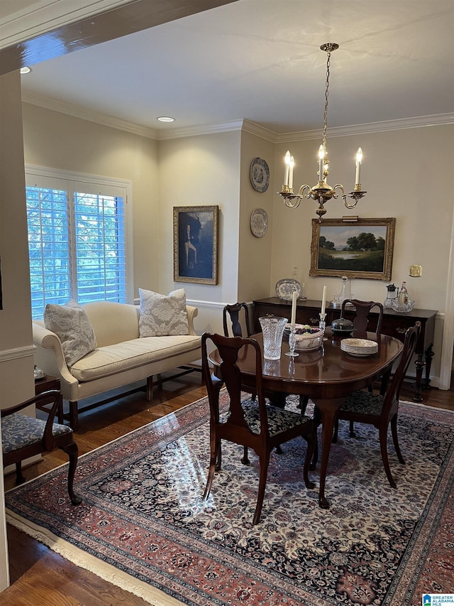 dining space featuring ornamental molding, a chandelier, and wood finished floors