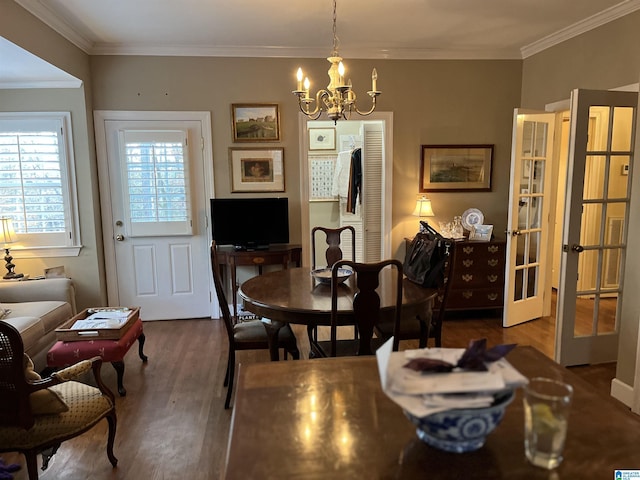 dining room featuring dark wood-style floors, ornamental molding, a notable chandelier, and french doors