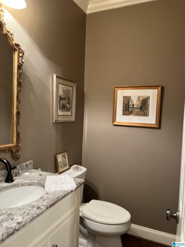 bathroom with toilet, vanity, and baseboards