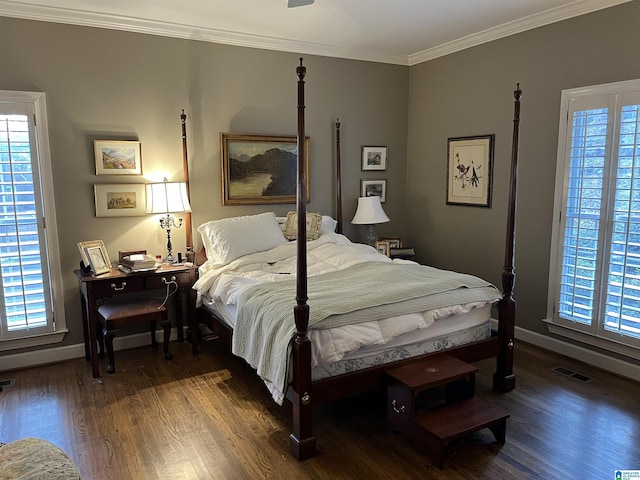 bedroom with ornamental molding, visible vents, baseboards, and wood finished floors