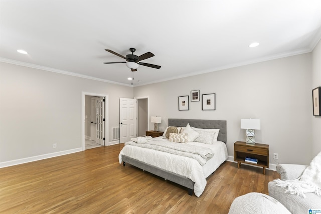 bedroom with baseboards, visible vents, ornamental molding, wood finished floors, and recessed lighting