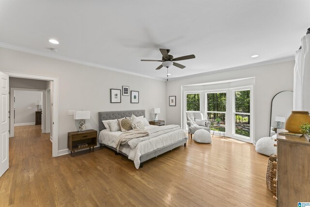 bedroom featuring crown molding, baseboards, wood finished floors, and recessed lighting