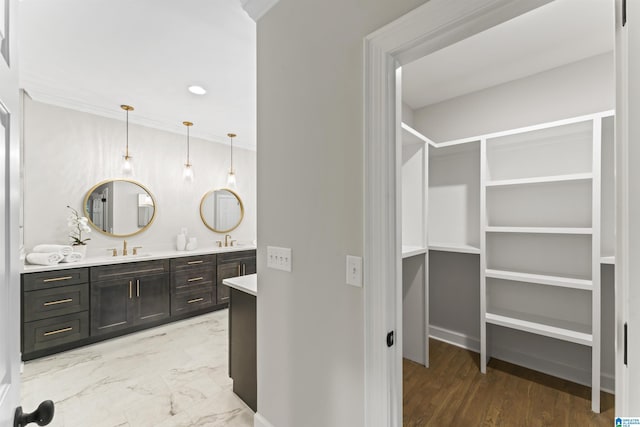 full bath featuring a sink, double vanity, a walk in closet, and marble finish floor