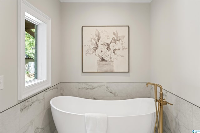 full bathroom featuring a freestanding bath, wainscoting, and tile walls