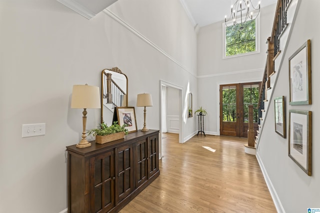 foyer entrance featuring ornamental molding, plenty of natural light, stairway, and light wood finished floors