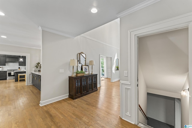 corridor featuring light wood-type flooring, baseboards, crown molding, and recessed lighting