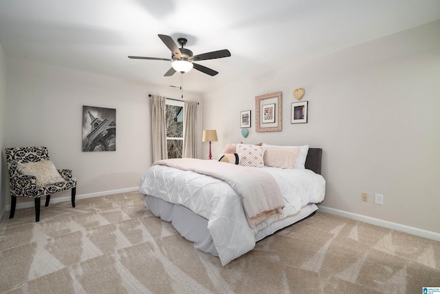 bedroom with light carpet, ceiling fan, and baseboards