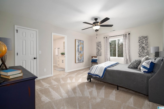 bedroom with light colored carpet, connected bathroom, baseboards, and ceiling fan