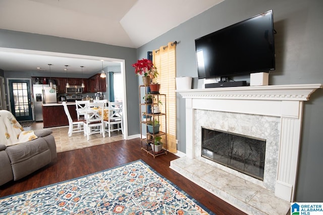 living room with vaulted ceiling, a premium fireplace, and dark hardwood / wood-style floors