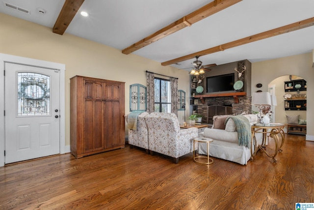 living room with beam ceiling, a fireplace, wood finished floors, and visible vents