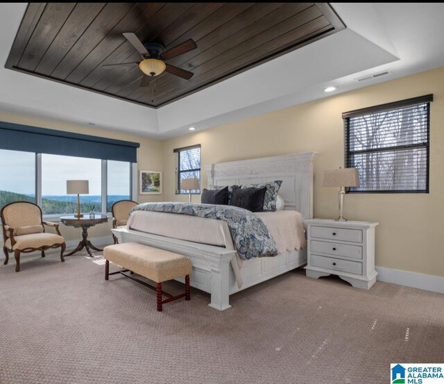 bedroom featuring carpet, a raised ceiling, visible vents, wood ceiling, and baseboards