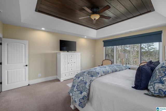 carpeted bedroom with wooden ceiling, baseboards, a raised ceiling, and a ceiling fan