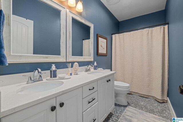 full bath with toilet, tile patterned flooring, double vanity, and a sink