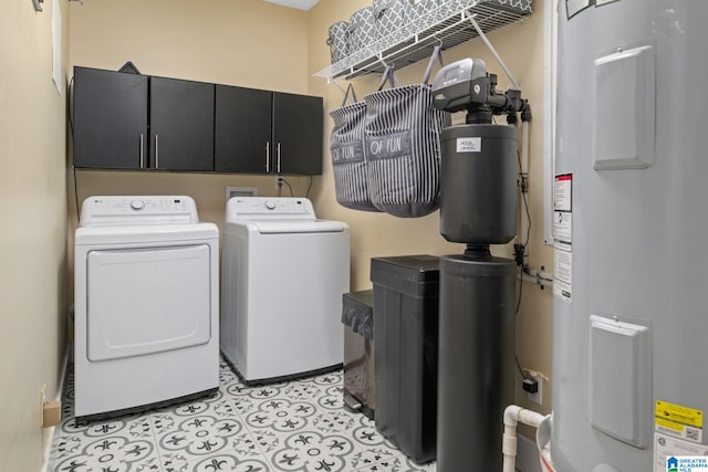 laundry room featuring washing machine and dryer, water heater, cabinet space, and light tile patterned floors