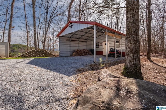 view of outbuilding featuring gravel driveway and a detached carport