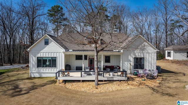 view of front of home featuring board and batten siding, roof with shingles, and a front lawn