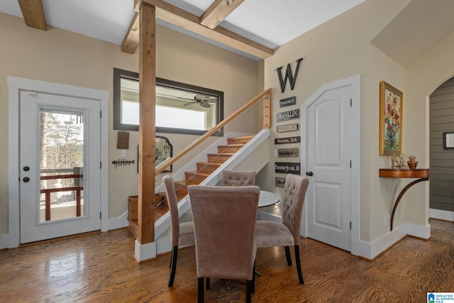 dining room featuring baseboards, stairway, beamed ceiling, and wood finished floors