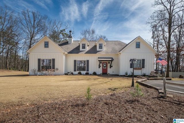 view of front of property with a chimney, a shingled roof, board and batten siding, and a front yard