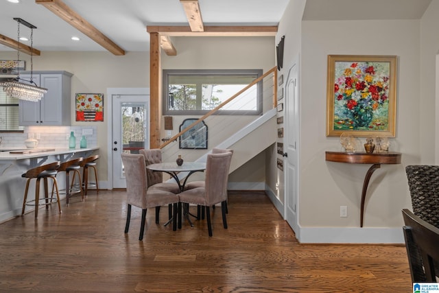 dining space featuring dark wood-style floors, baseboards, and beamed ceiling