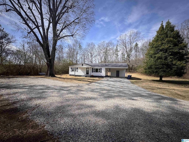 single story home with gravel driveway