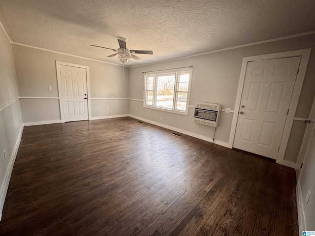 spare room featuring heating unit, ornamental molding, and dark wood-style flooring