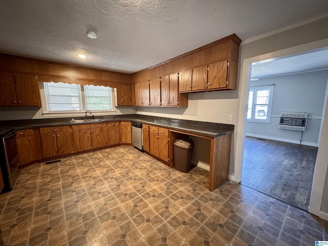 kitchen featuring stainless steel appliances, a sink, heating unit, brown cabinetry, and dark countertops