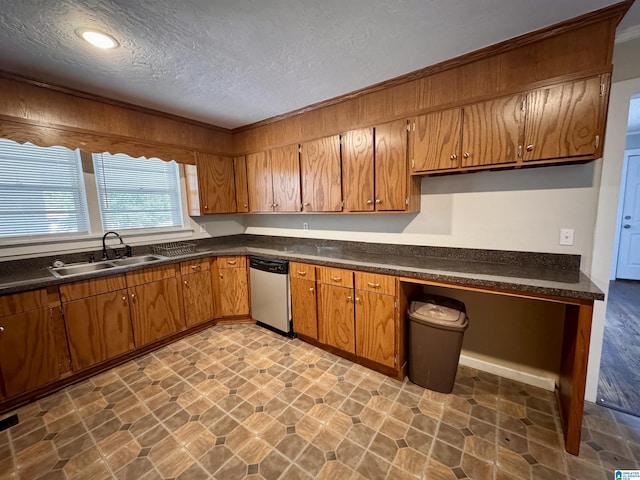 kitchen featuring brown cabinetry, dark countertops, and stainless steel dishwasher