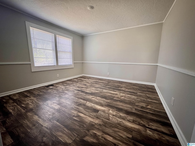 empty room featuring baseboards, crown molding, visible vents, and dark wood-style flooring