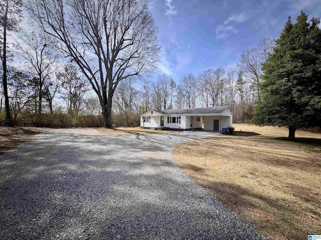 single story home with gravel driveway