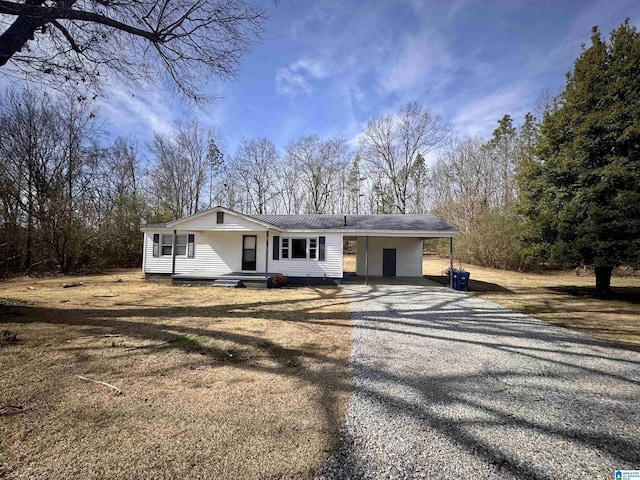 ranch-style home with a carport, metal roof, and driveway