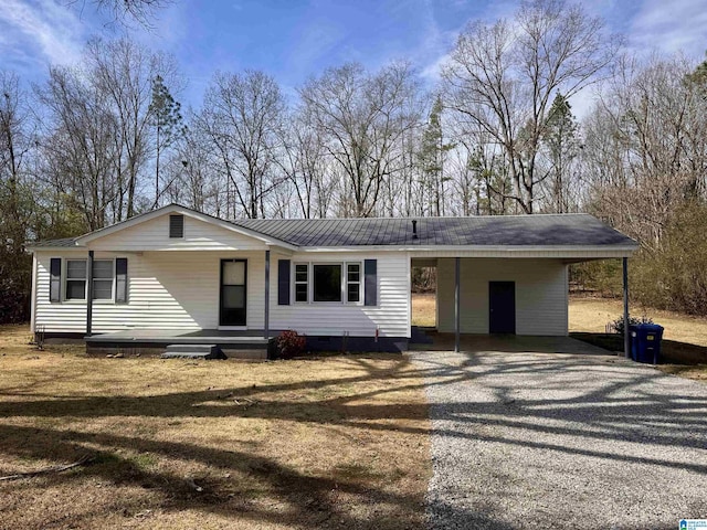 view of front of house with metal roof, driveway, an attached carport, and crawl space