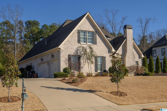 view of front of property with a garage, a chimney, concrete driveway, and brick siding