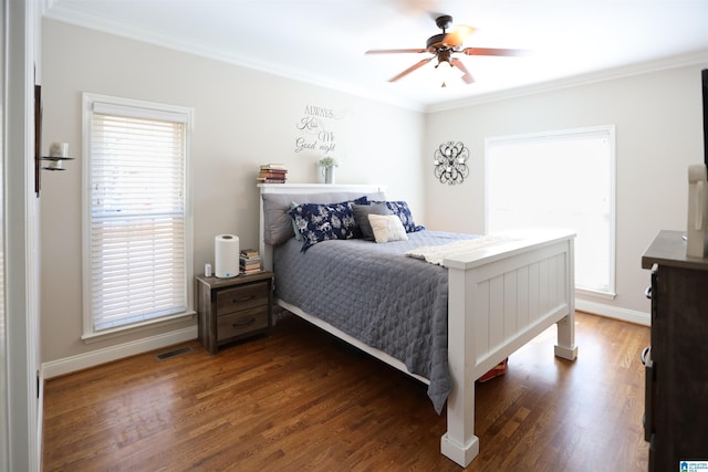 bedroom featuring baseboards, dark wood-style flooring, visible vents, and crown molding