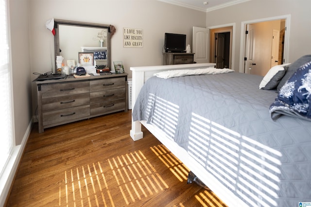 bedroom with baseboards, dark wood-style flooring, and crown molding