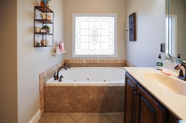 bathroom with a jetted tub, vanity, and tile patterned floors