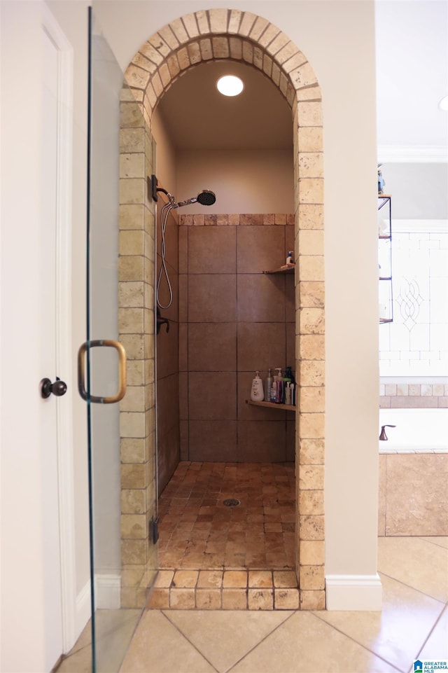 bathroom featuring a stall shower, tile patterned flooring, and a bath