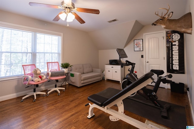 workout area featuring baseboards, visible vents, a ceiling fan, wood finished floors, and vaulted ceiling