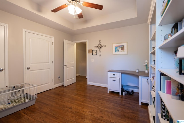 office featuring a ceiling fan, baseboards, a raised ceiling, and dark wood finished floors