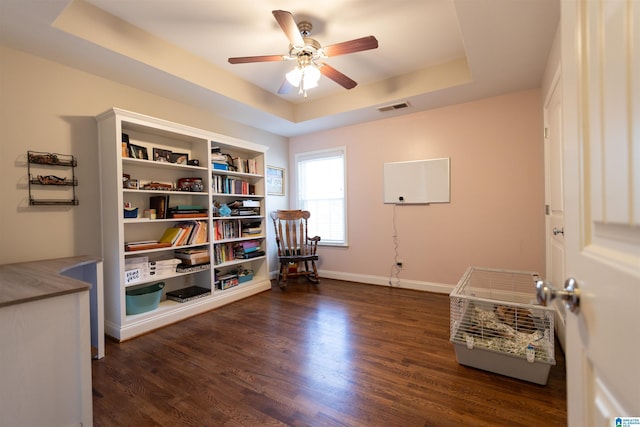 sitting room featuring a tray ceiling, visible vents, ceiling fan, wood finished floors, and baseboards