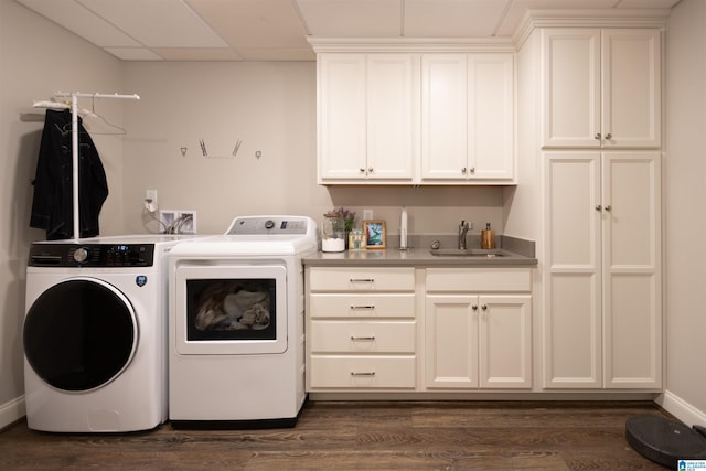 laundry area with cabinet space, washing machine and dryer, dark wood-style flooring, and a sink